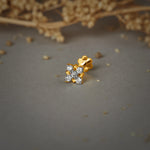 Pure gold nose pin with floral diamond design on soft neutral background, elegant women’s nose stud jewelry