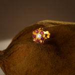 Stone Nose Pin Gold gemstones on a brown textured surface
