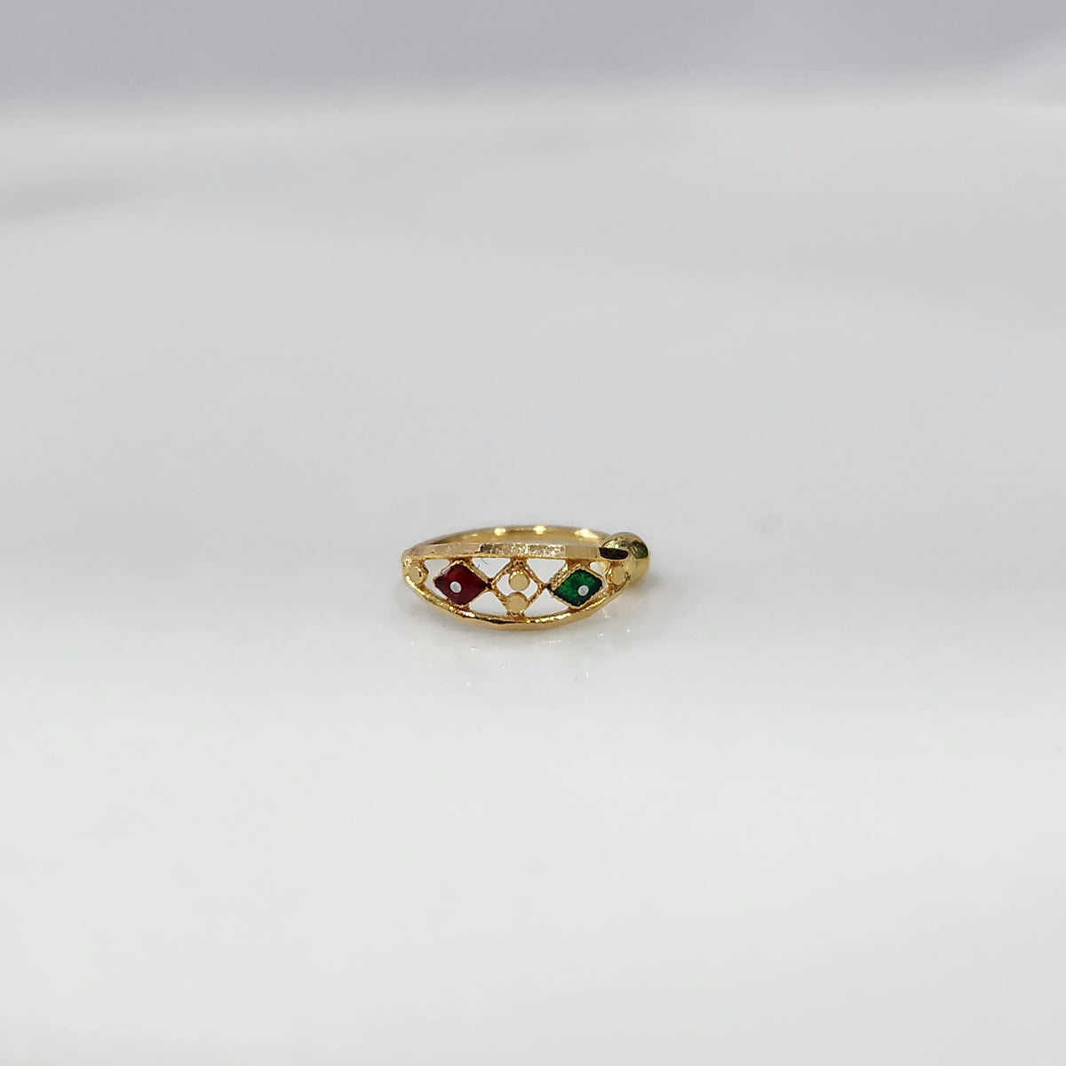 Festive Mosaic Gold Nose Pin by Yuvora in 18K gold with red and green stone design displayed on white background