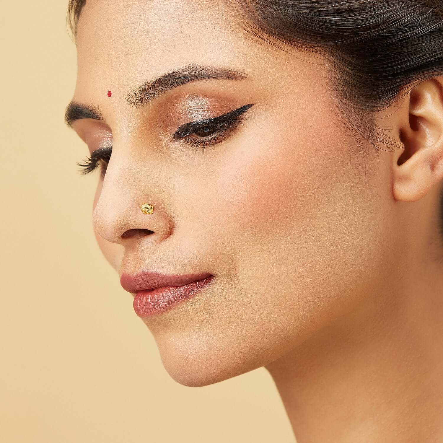 Model wearing a five-petal 18k gold nose pin with an elegant floral design, adding a touch of traditional charm and modern style.