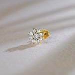 Floral cluster design of gold nose pin with sparkling diamonds on soft background