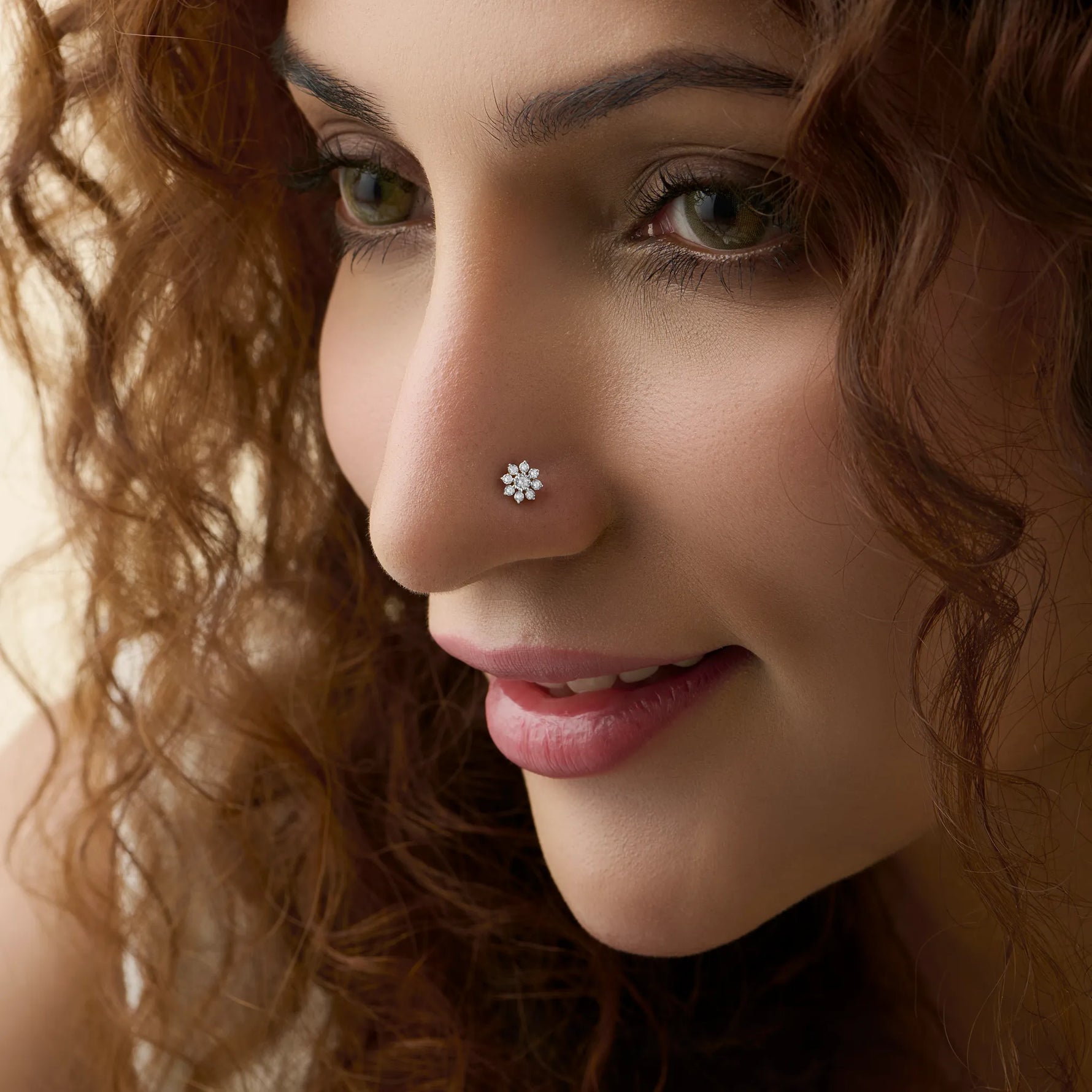 Woman wearing elegant design of gold nose pin with diamond floral style