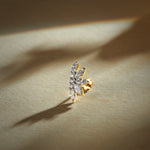 Flower nose pin gold with elongated floral leaf design featuring multiple sparkling stones set in a polished gold base on a soft neutral background
