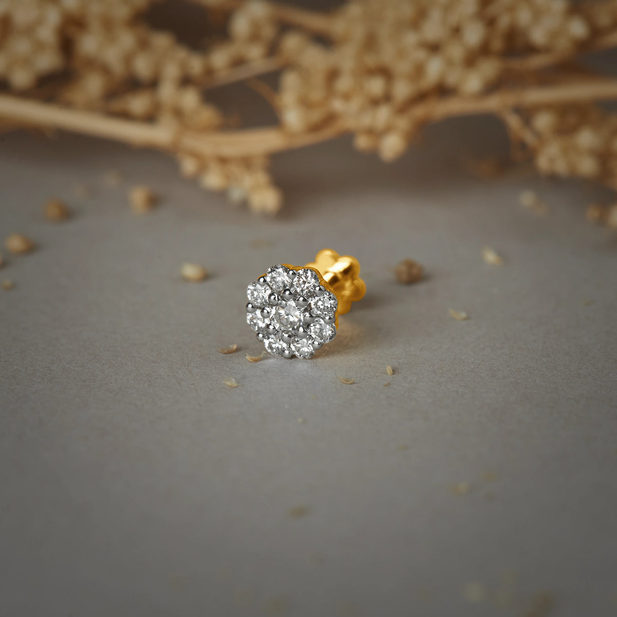 Nose pin gold with round cluster design featuring multiple sparkling stones set in a polished gold base on a soft neutral background