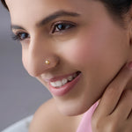 Woman wearing a minimal gold nose pin showcasing a soft everyday look with a gentle smile