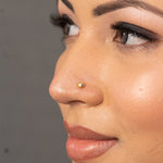 Woman wearing a small 18K nose pin gold showing a minimal and elegant everyday look