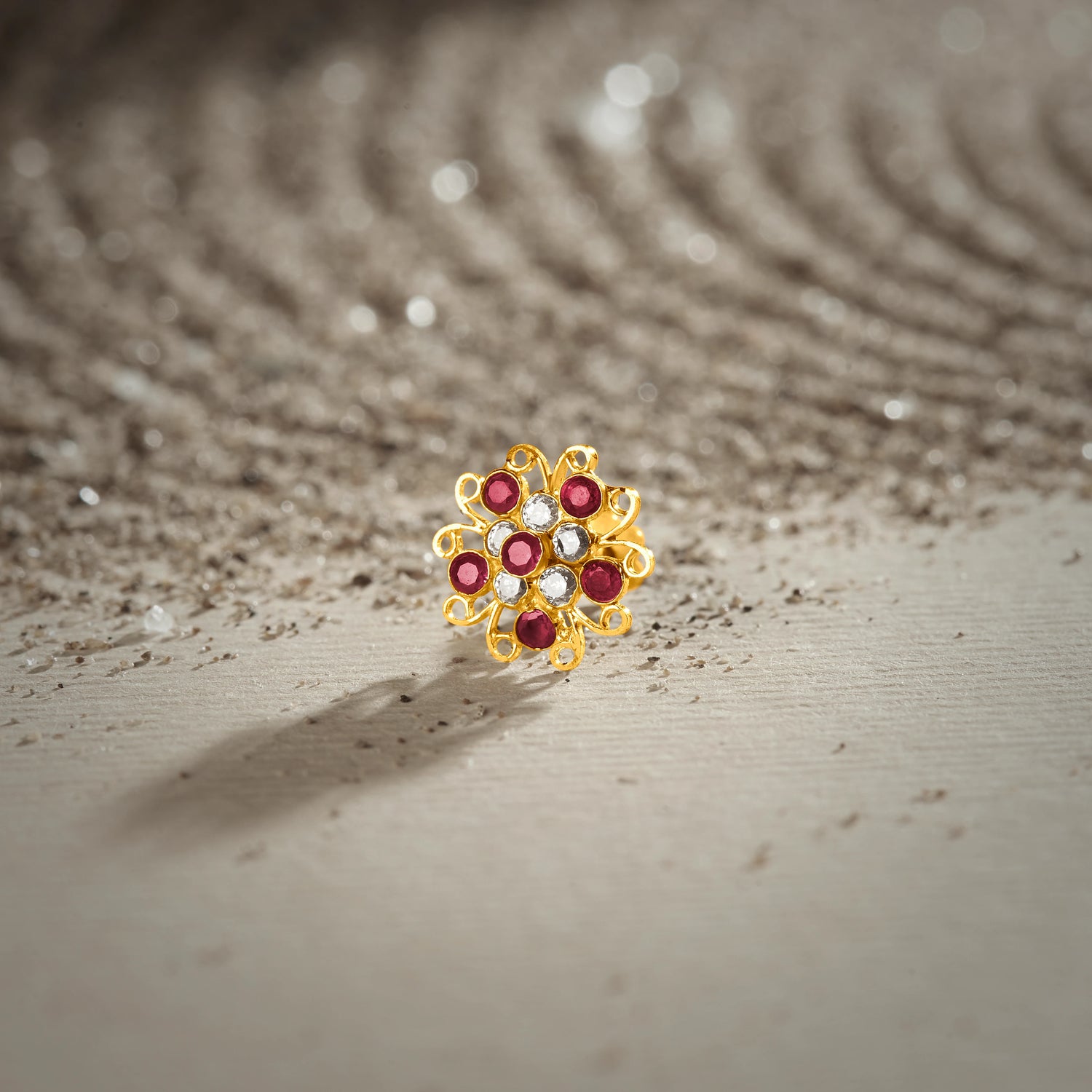 Nose pin new design gold with multicolor floral stones on textured surface