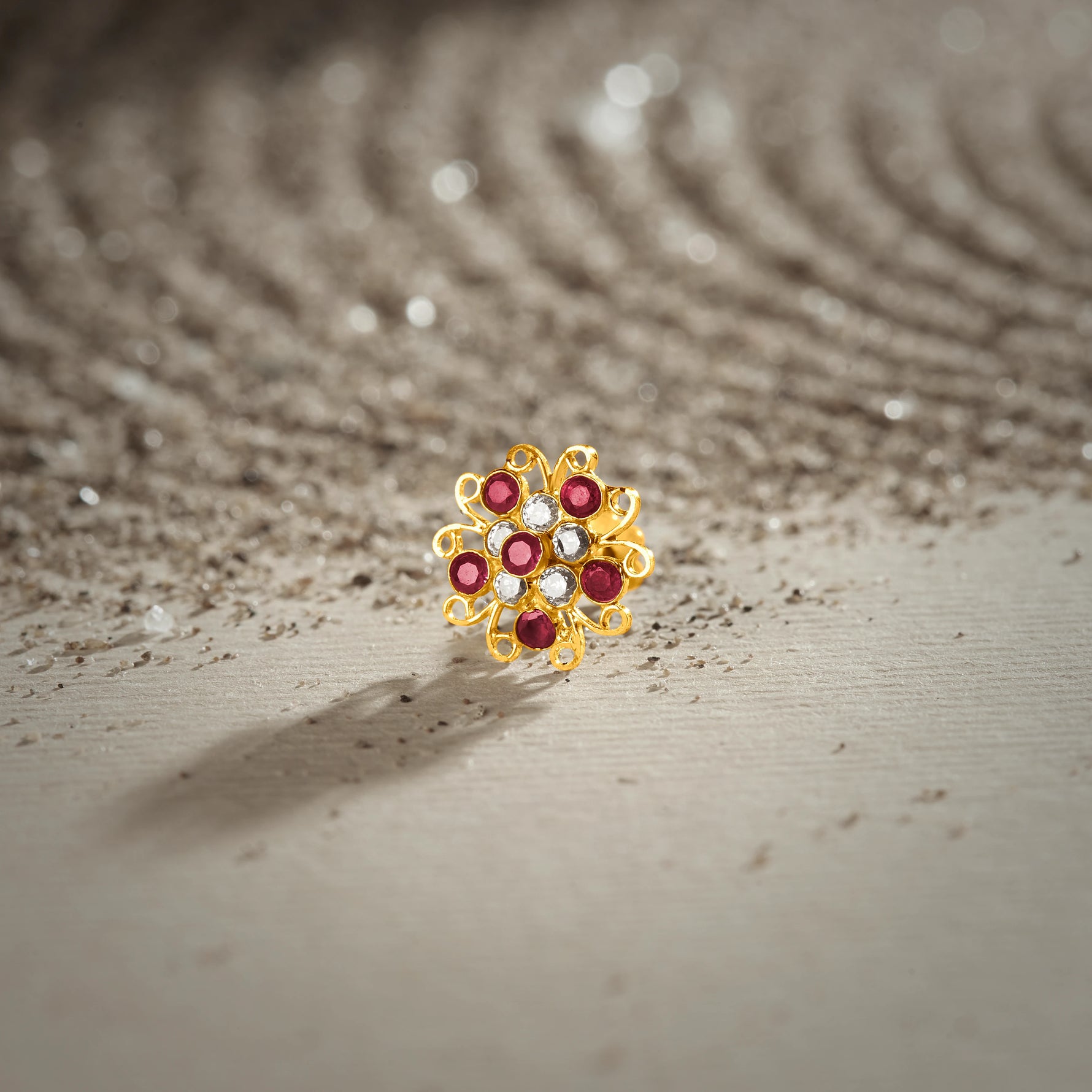 Nose pin new design gold with multicolor floral stones on textured surface