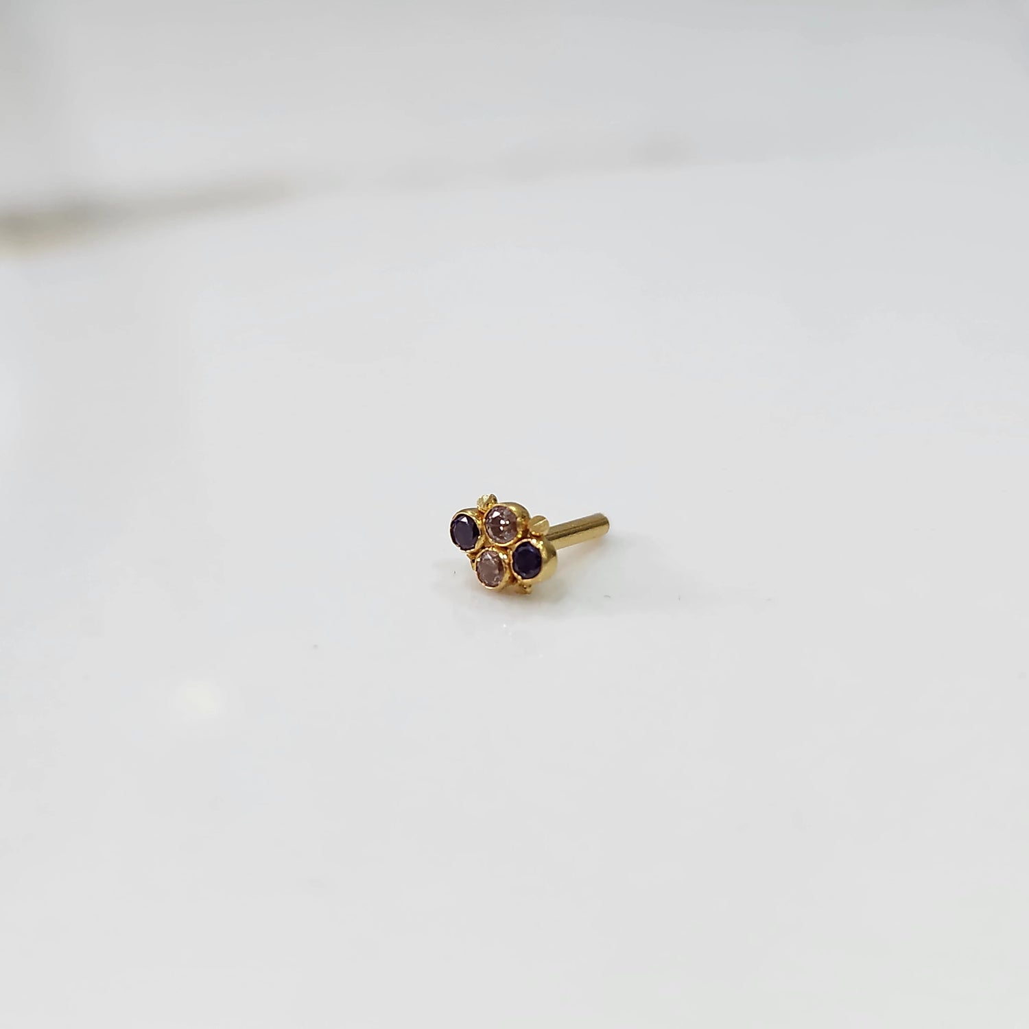 Women's gold nose pin design with floral cluster on white background