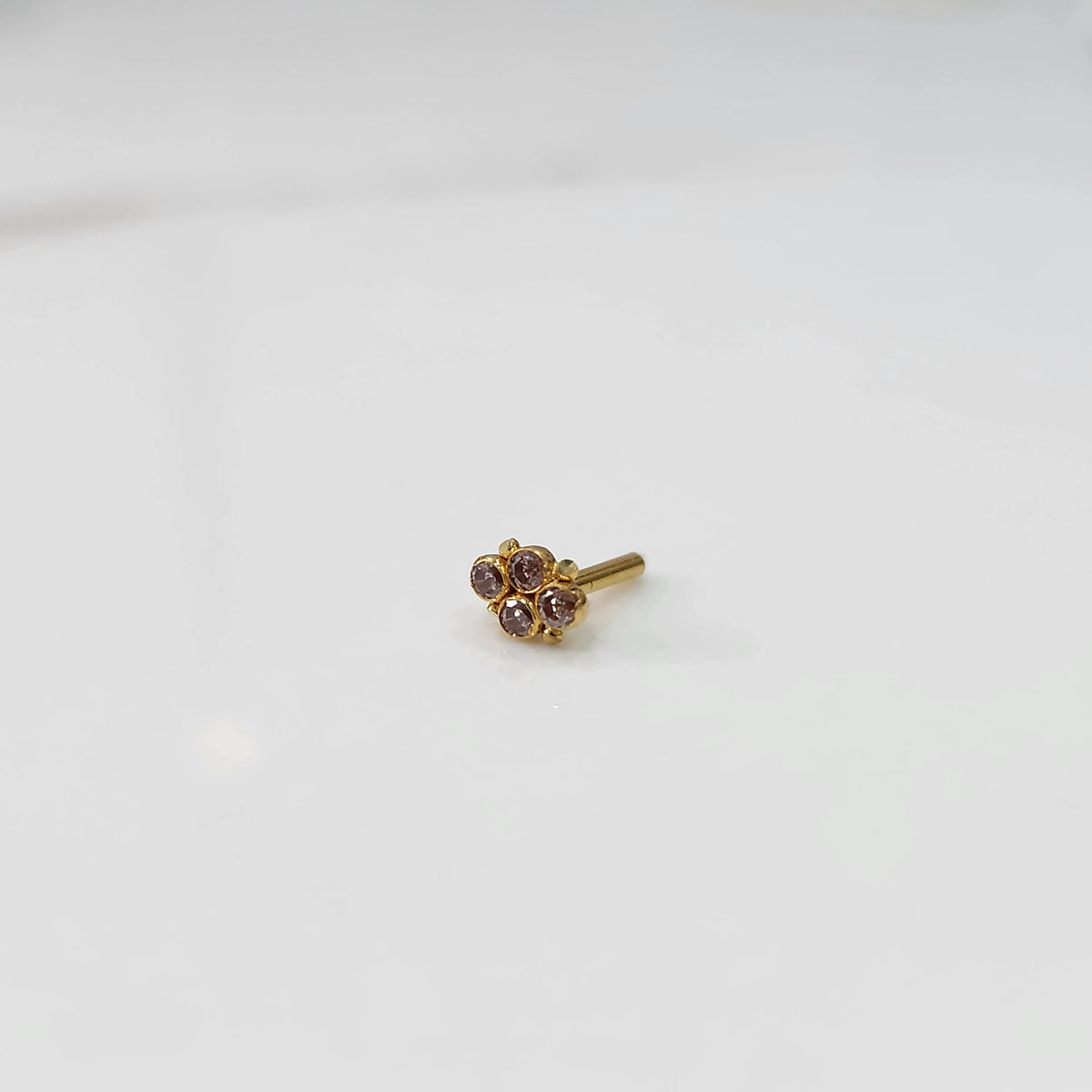 Women's gold nose pin design side view with small gemstone floral design