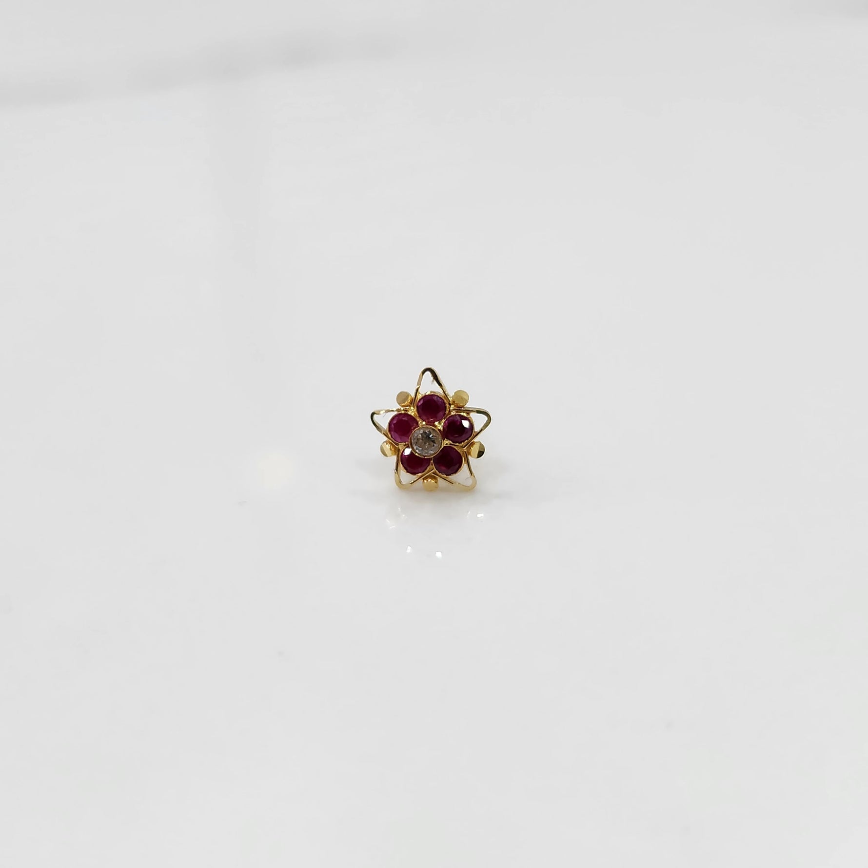 Nose pin design gold with multicolor stones in compact floral design