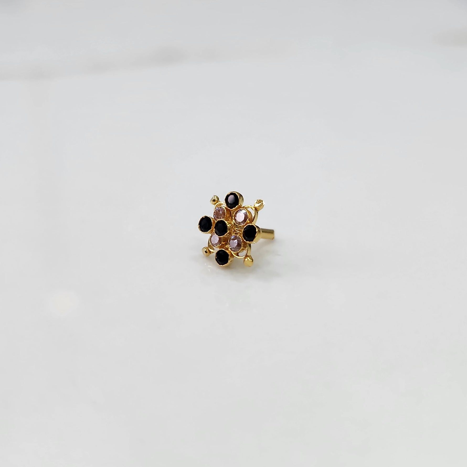 Delicate stone gold nose pin floral design close up