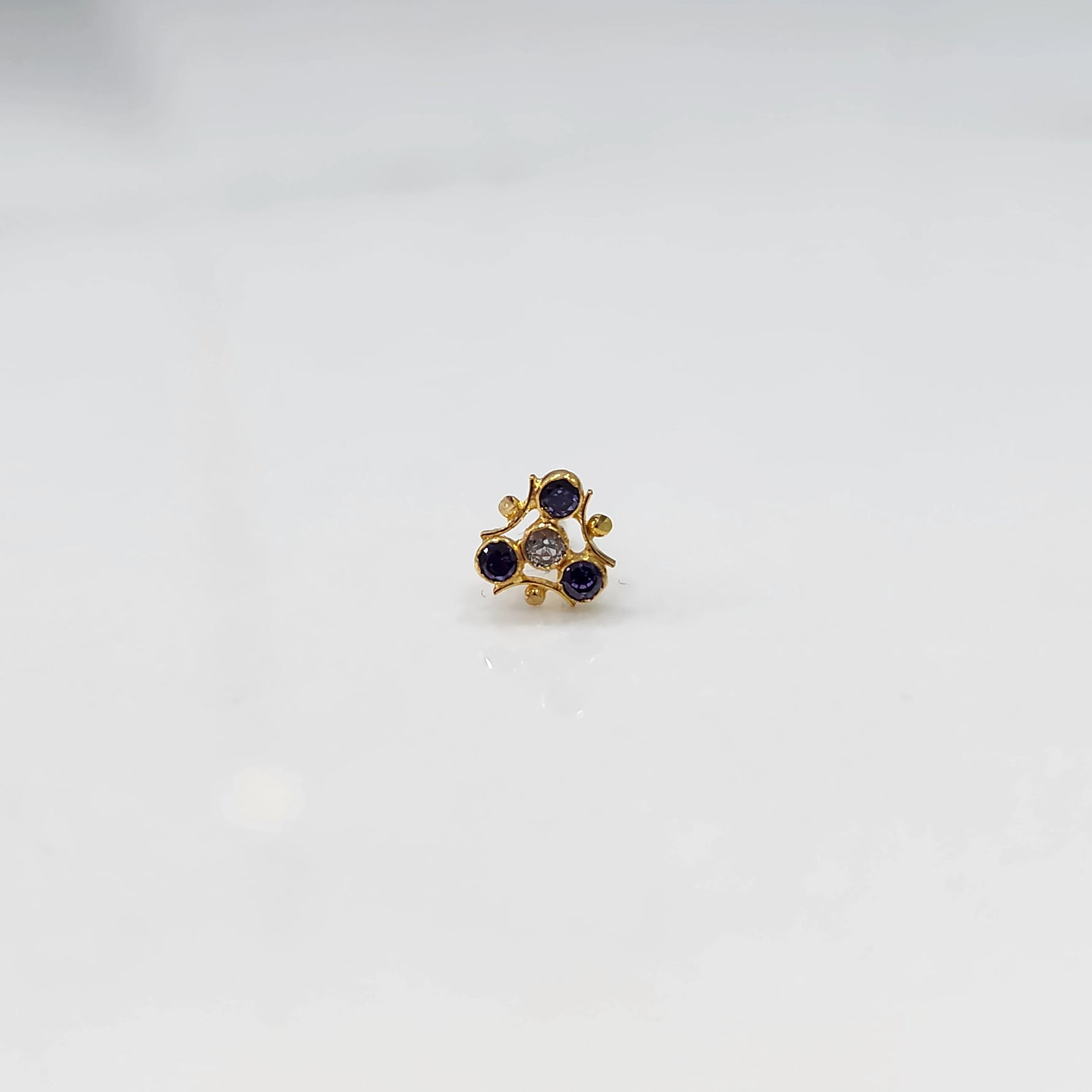 Tiny nose pin gold with floral pattern on white background
