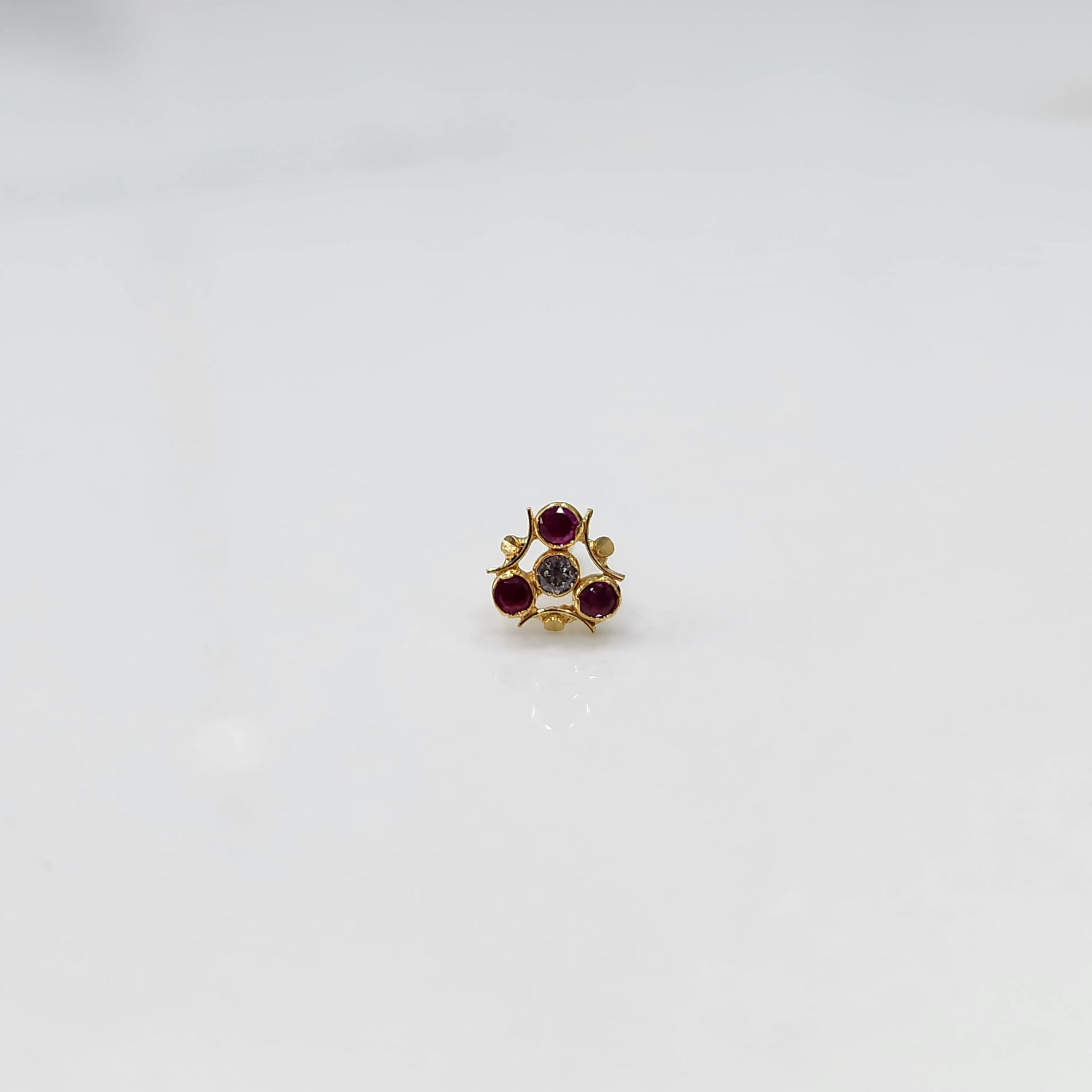 Tiny nose pin gold with floral stone cluster on white background