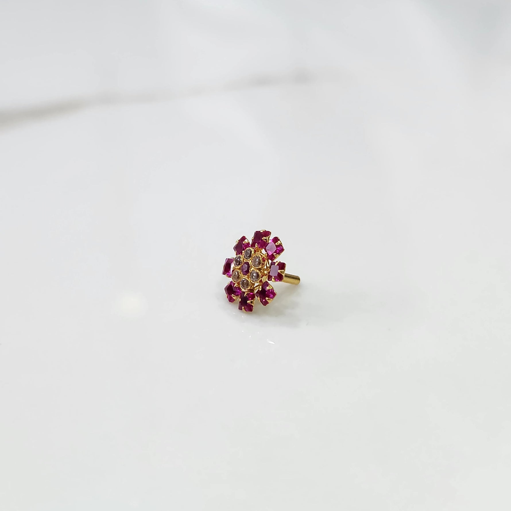 Gold nose pin design with pink gemstone floral cluster