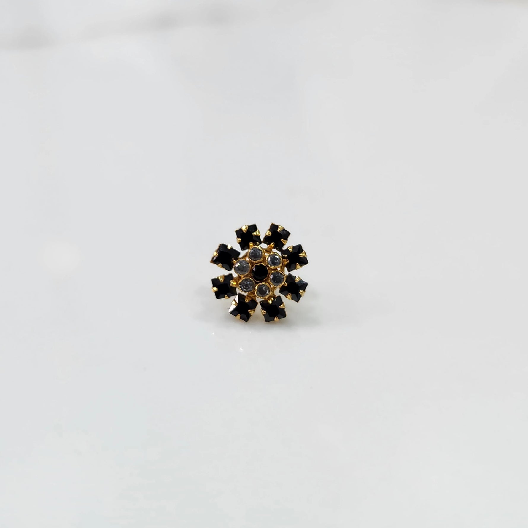 Gold nose pin design with black stone floral pattern