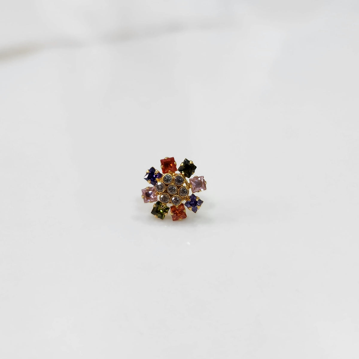 Gold nose pin design with multicolor floral cluster on white background