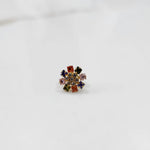 Gold nose pin design with multicolor floral cluster on white background