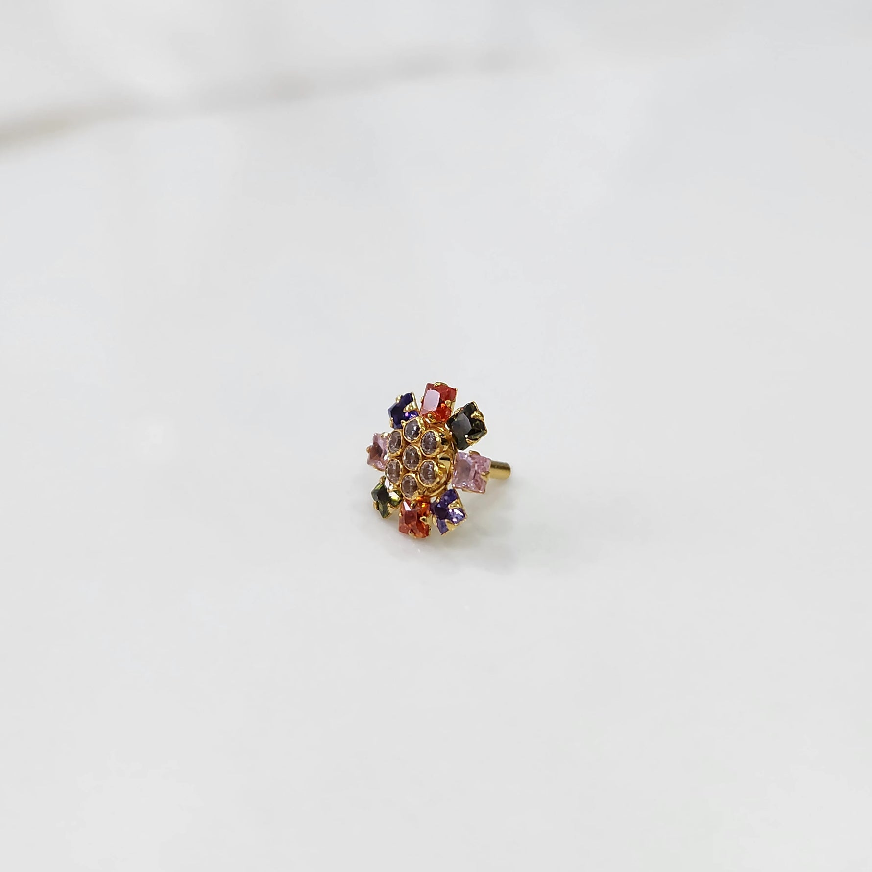 Side view gold nose pin design with colorful gemstone setting