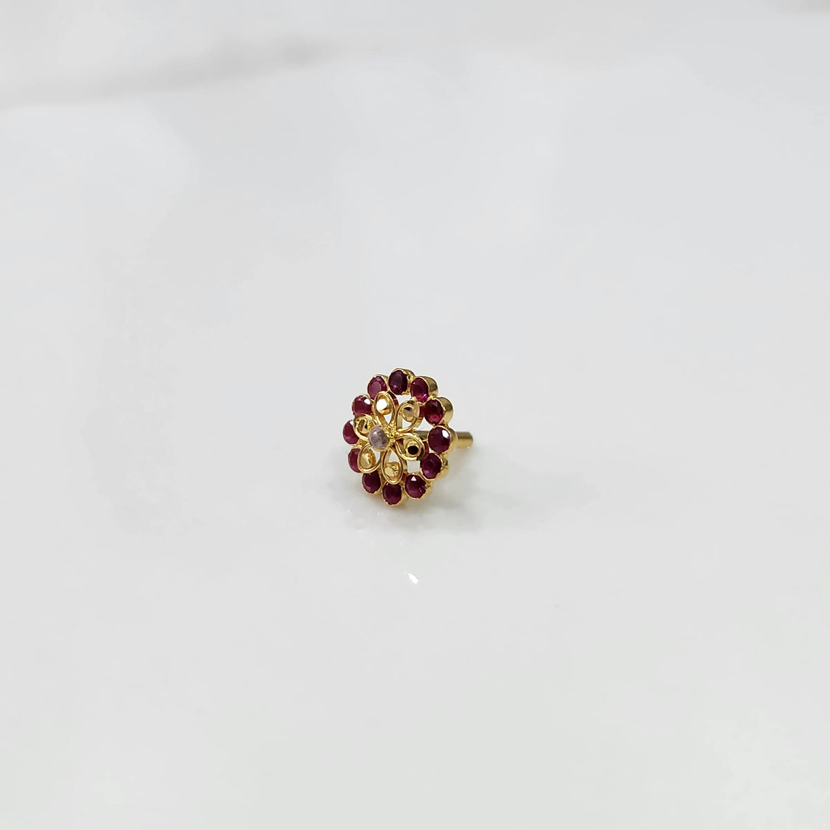 Gold nose pin design with oval red gemstone floral style