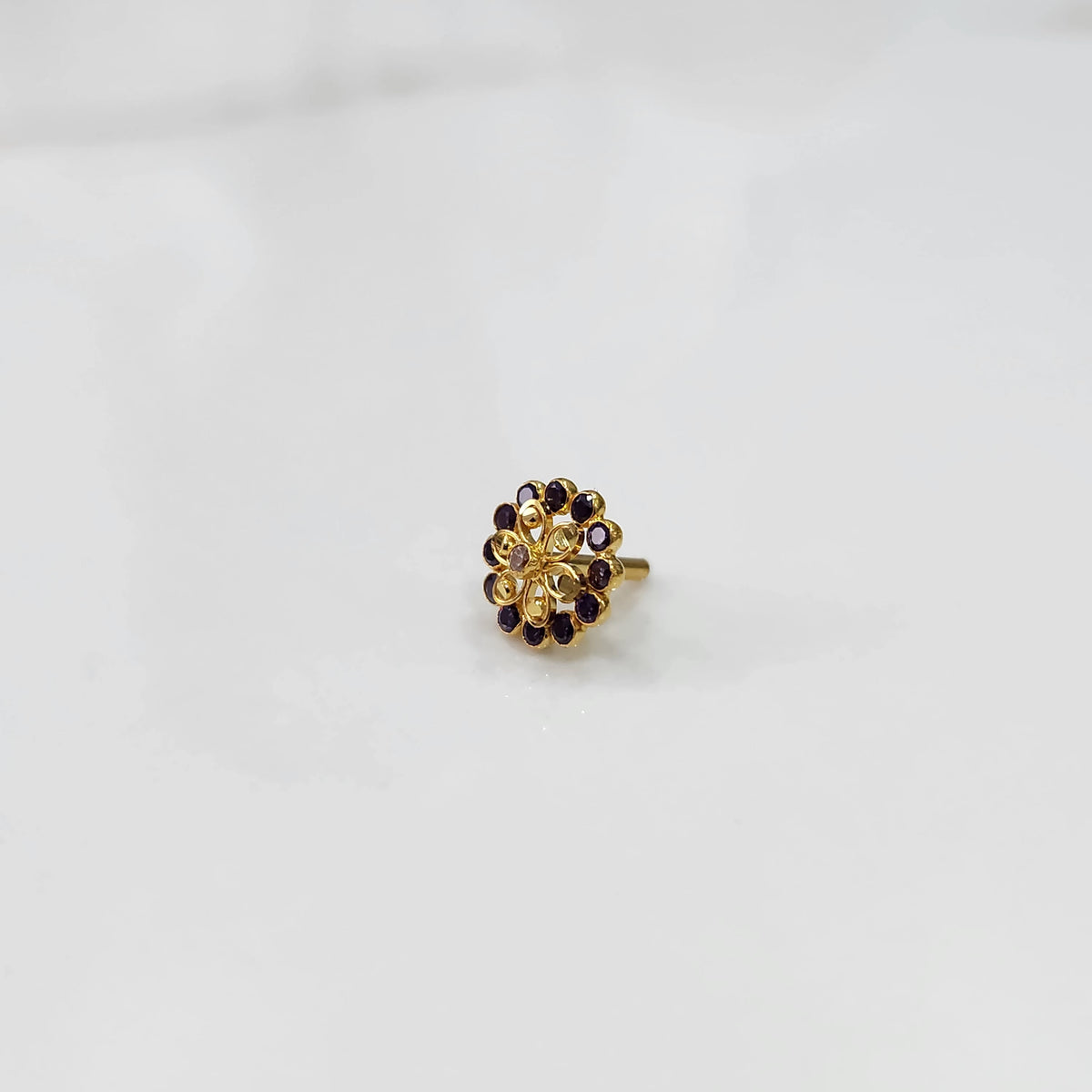Gold nose pin design with compact floral gemstone setting