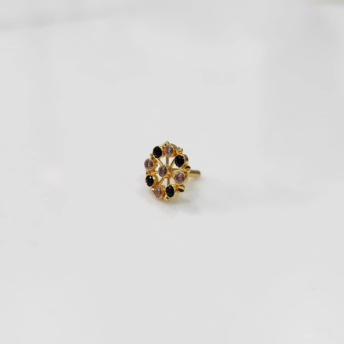 Gold pin nose with red and white floral stones on white background