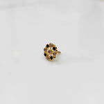 Gold pin nose with red and white floral stones on white background