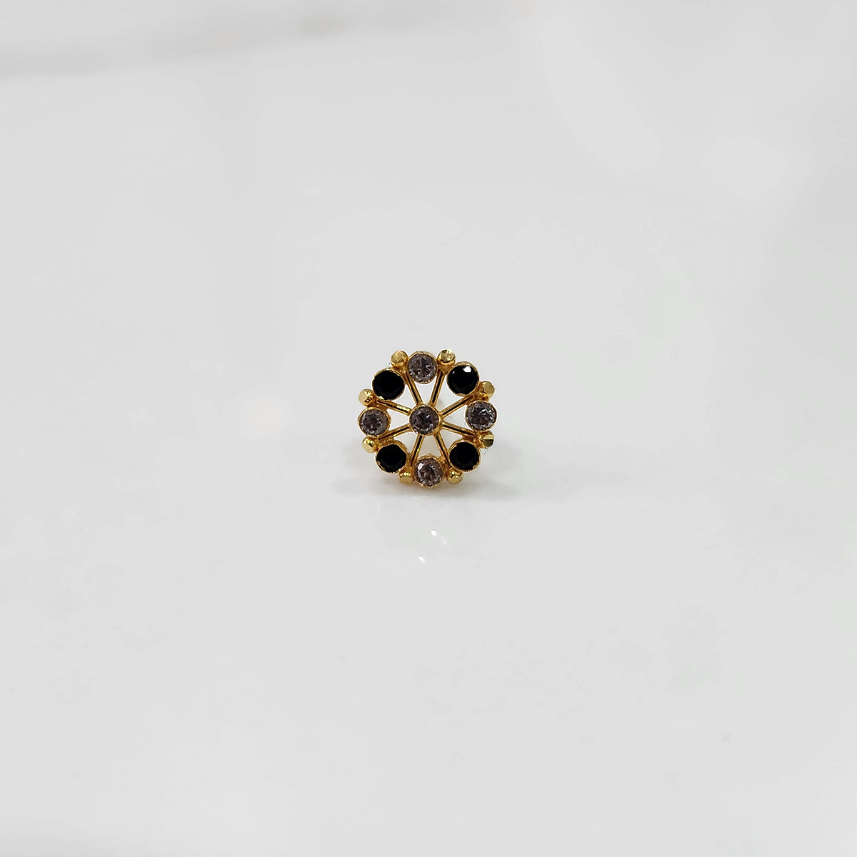 Front view gold pin nose with circular floral stone pattern