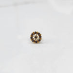 Close up gold pin nose with multicolor floral arrangement