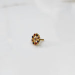 Gold pin nose with intricate multicolor floral setting on white background