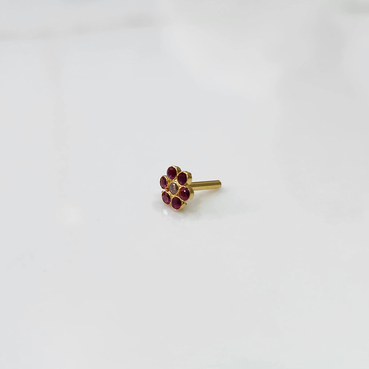 Nose pin design gold with multicolor floral stones side angle on white background