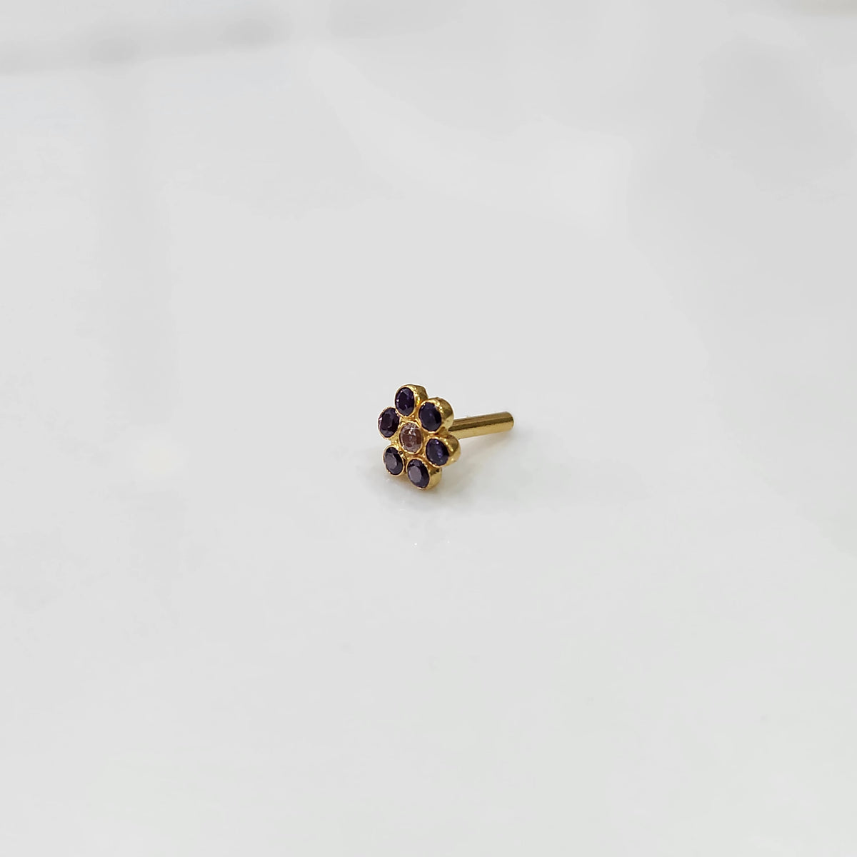 Nose pin design gold with blue stone floral cluster front view on white background