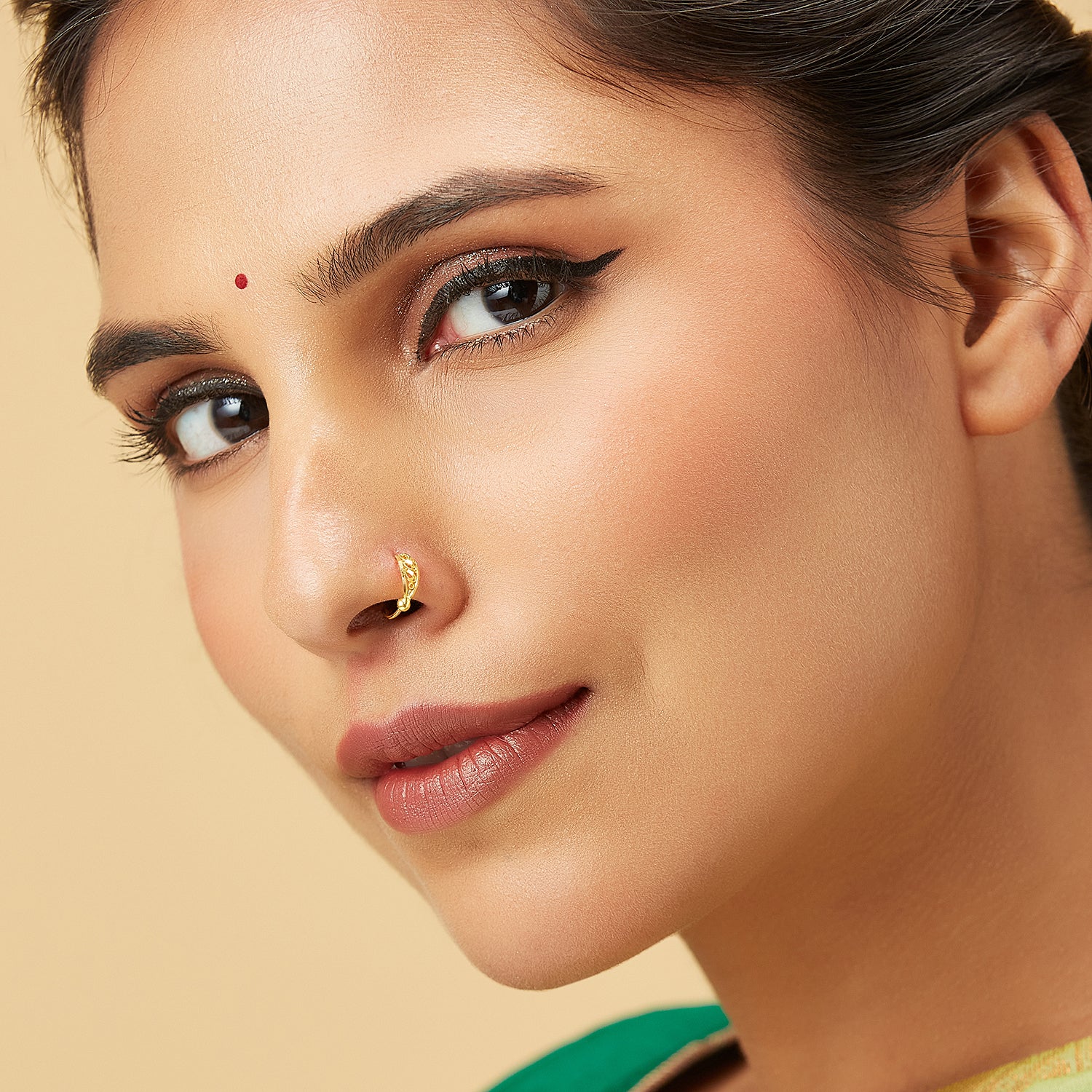 Model wearing Allure Twist Gold Nose Ring by Yuvora in 18K gold with elegant vine-inspired twist design, perfect jewellery for oval-shaped face