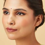 Auric Corona gold nose pin in 18K worn by model, radiant circular sunrise-inspired design jewelry for women