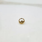 Encircled Waves gold nose pin in 18K gold displayed on plain surface showcasing elegant circular wave design