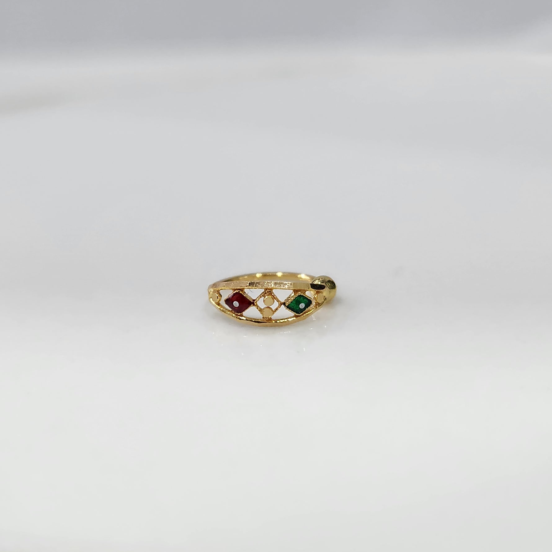Festive Mosaic Gold Nose Pin by Yuvora in 18K gold with red and green stone design displayed on white background