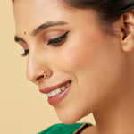 Model wearing Festive Mosaic Gold Nose Pin by Yuvora in 18K gold with red and green design, traditional jewellery for celebrations