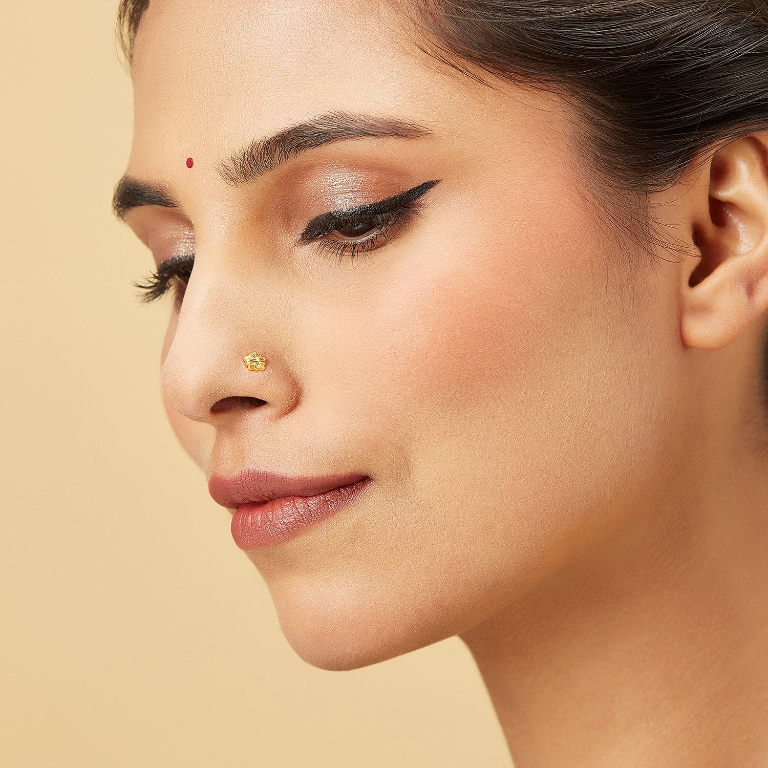 Model wearing a five-petal 18k gold nose pin with an elegant floral design, adding a touch of traditional charm and modern style.