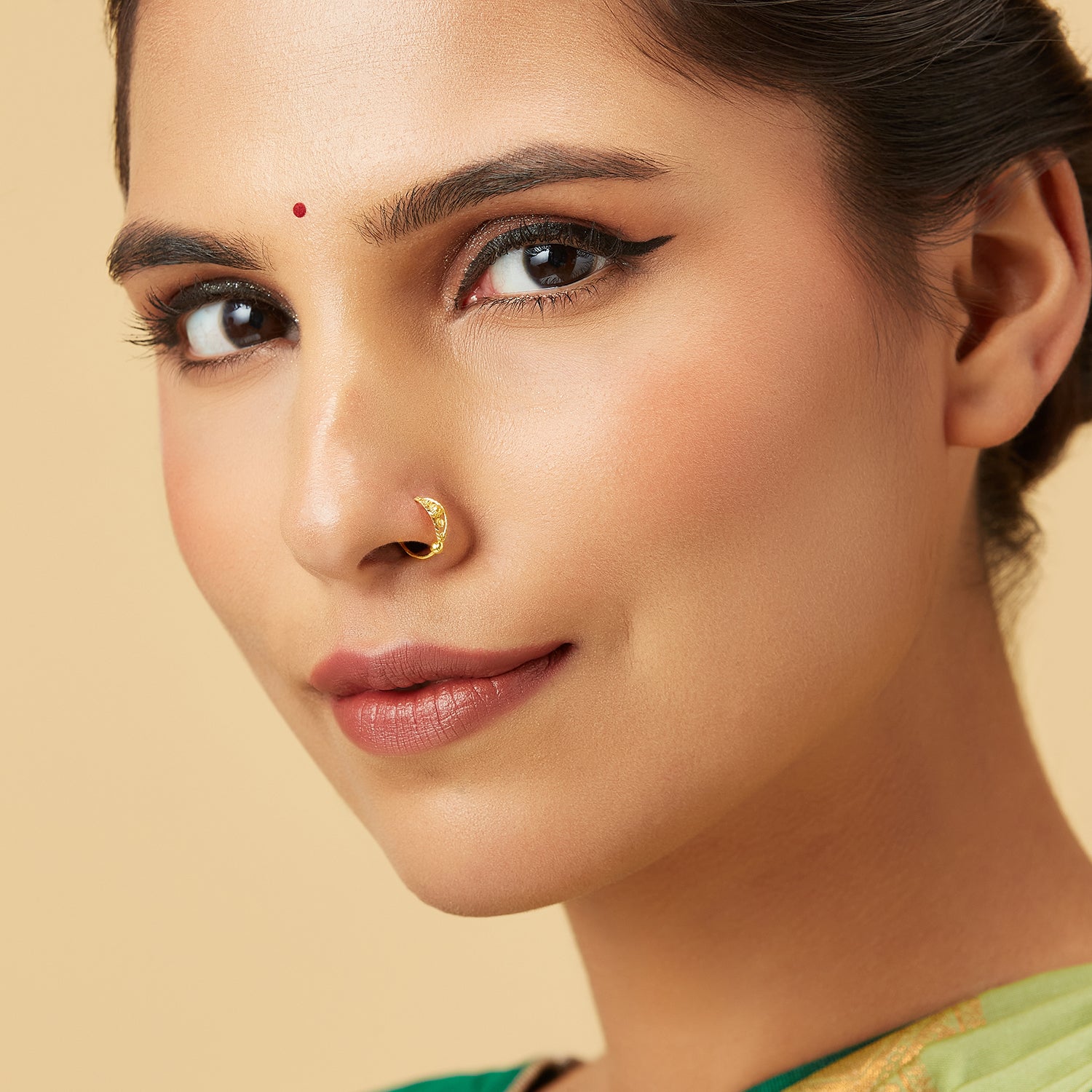 Model wearing Golden Mosaic Gold Nose Ring by Yuvora in 18K gold with traditional sun motif and filigree design, perfect jewellery for round-shaped face