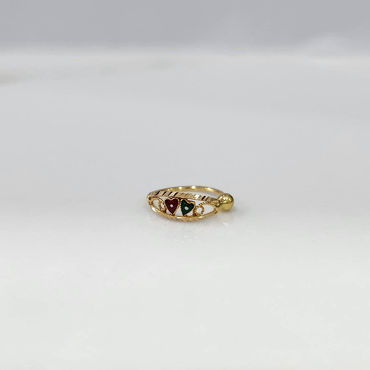 Heart Duet Gold Nose Ring by Yuvora in 18K gold with red and green dual heart design displayed on white background