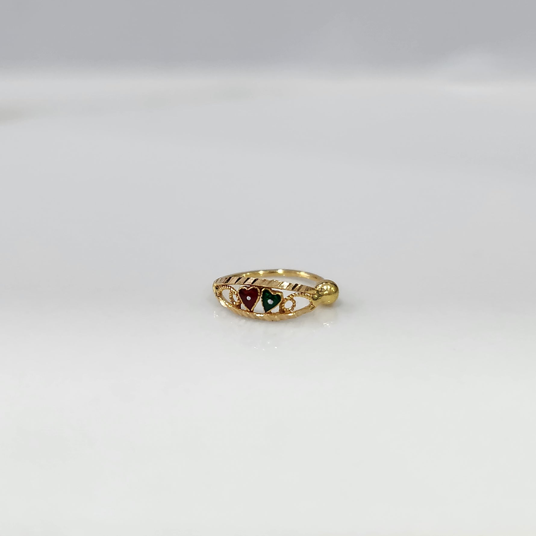 Heart Duet Gold Nose Ring by Yuvora in 18K gold with red and green dual heart design displayed on white background