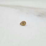 Honeycomb Drop gold nose pin in teardrop design with intricate hexagonal cutouts placed on a white surface