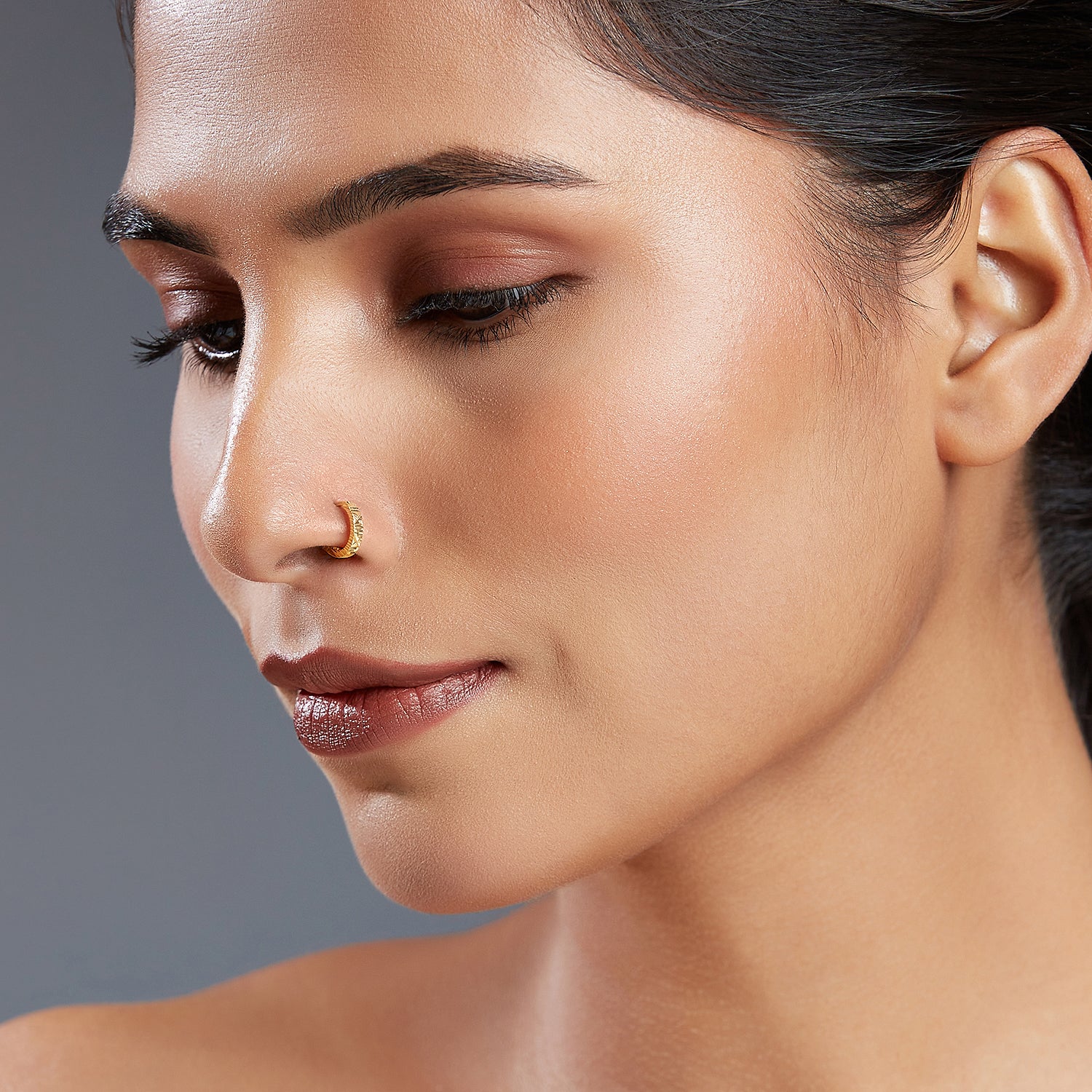 Model wearing Luxora Fusion gold nose pin in 18K gold, showcasing elegant geometric design for diamond-shaped faces