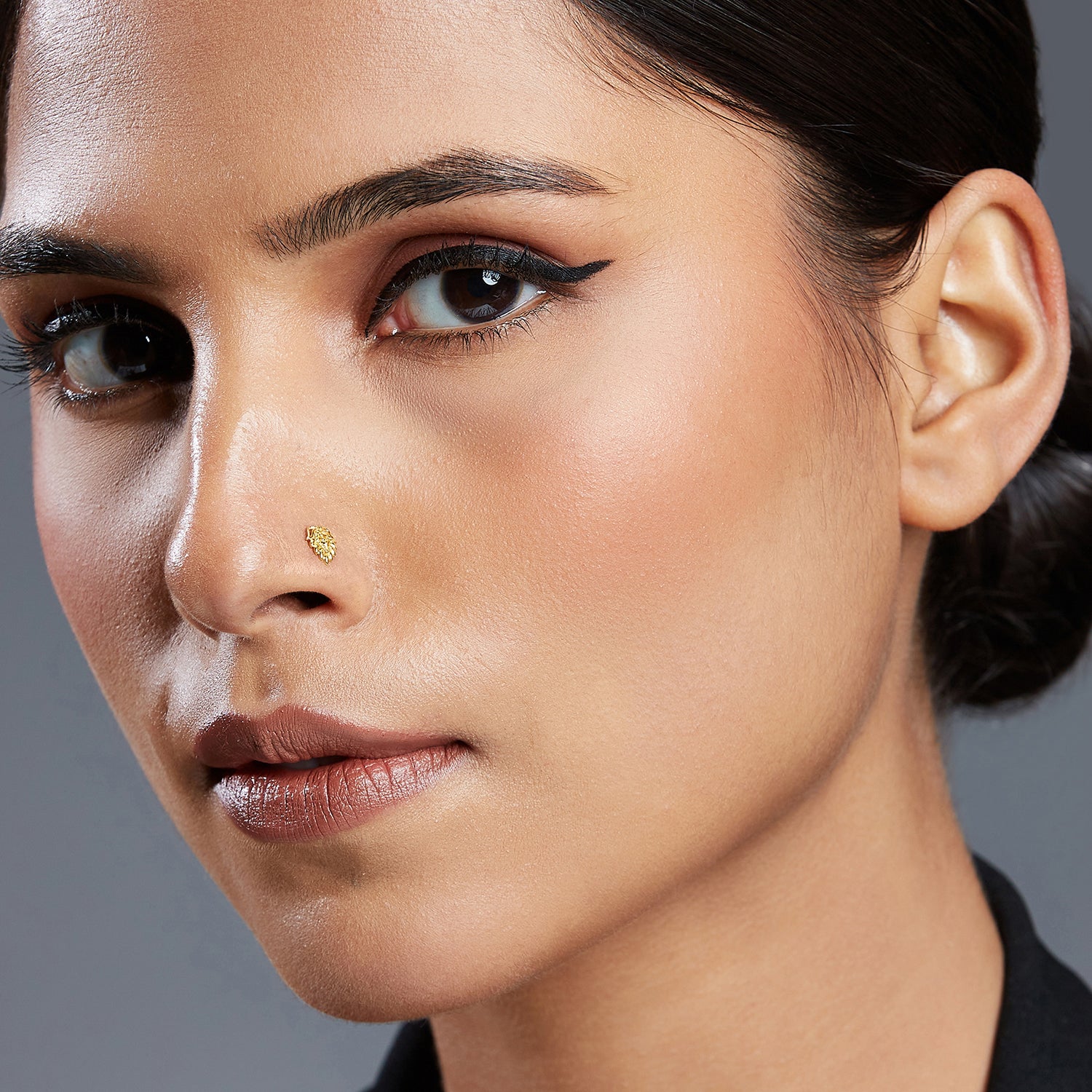Woman wearing Peacock Plume gold nose pin with feather-inspired traditional design for festive and elegant look