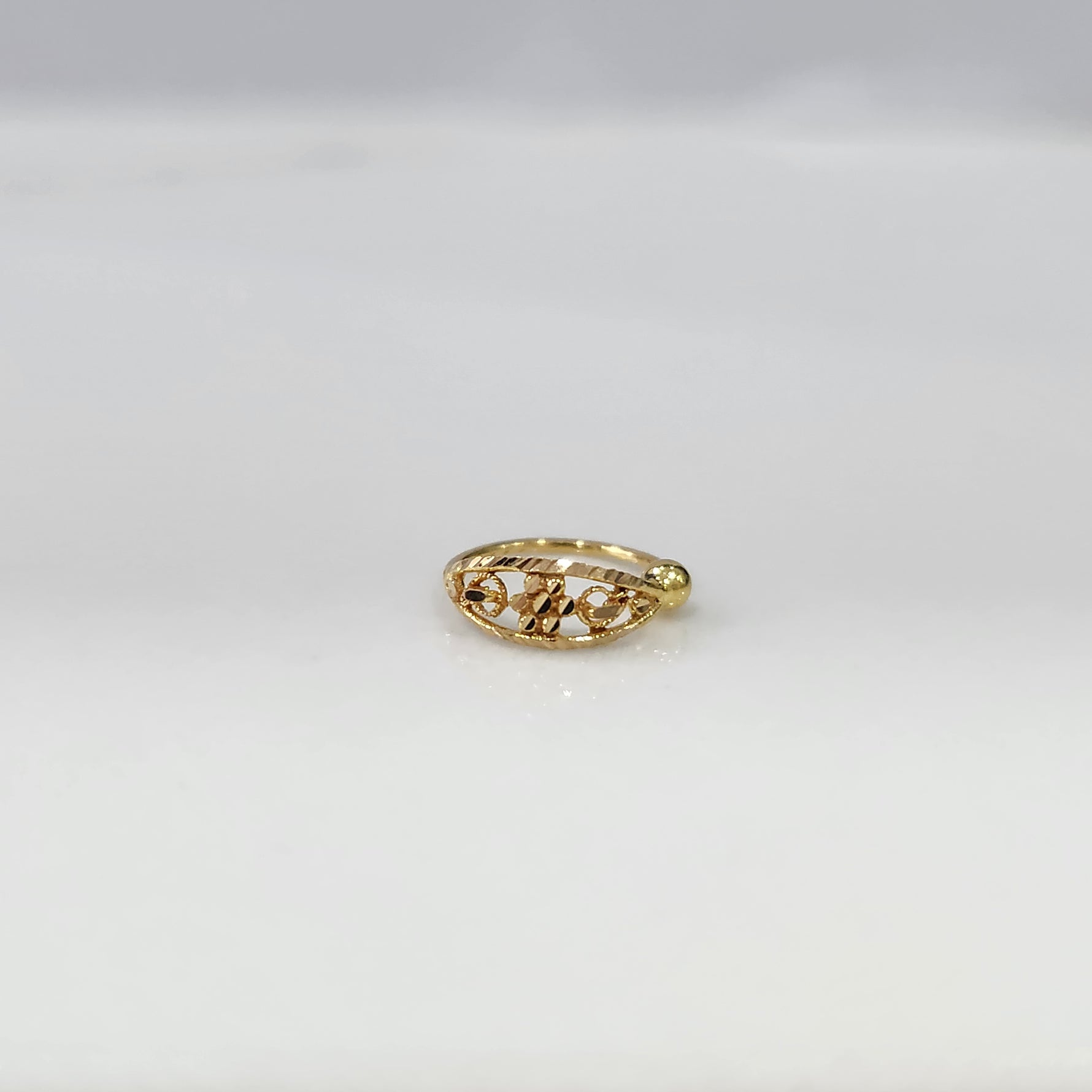 Petal Gold Nose Ring by Yuvora in 18K gold with floral filigree design, flat-lay view on white background