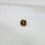 Petal Radiance gold nose pin with floral petal design placed on a flat surface, crafted in 18K gold