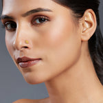 Model wearing Petal Radiance gold nose pin in 18K with elegant floral design, highlighting feminine charm and perfect for round-shaped faces