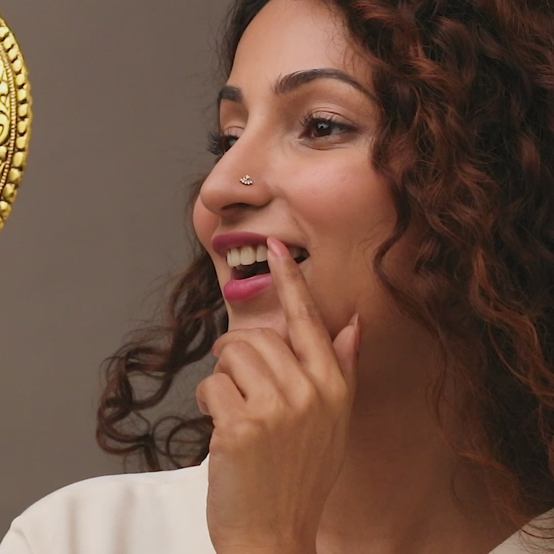 Gold nose pin worn on the nose in a close-up portrait, showcasing a graceful and elegant everyday jewelry look