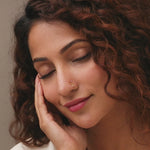 Woman wearing elegant Flower Delite stone gold nose pin with crimson stones