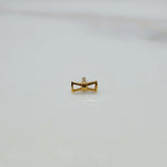 Close up of small hourglass gold nose pin design placed on white background ideal for elegant minimal look